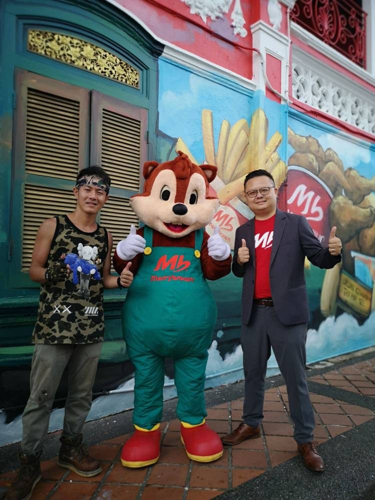 Sam Lim(左)、Marrybrown业务总监Michael Liew和吉祥物一起合影。-Marrybrown提供-