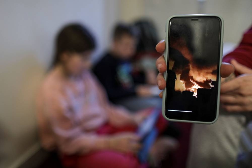 乌克兰指控俄罗斯投放具毁灭性威力的“真空弹”。图为逃往罗马尼亚的乌克兰民众展示国内遭俄军轰炸的视频。-路透社-