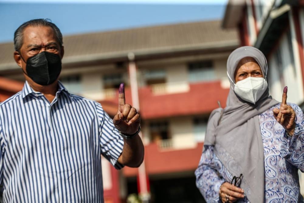 慕尤丁（左）与夫人诺莱妮，在斯里麻坡国中完成投票。-Hari Anggara摄-