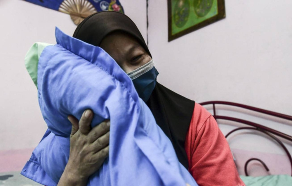 莎芭丽雅忆起已离世的儿子莫哈末阿兹哈，不禁悲从中来，抱紧儿子生前最爱的枕头。-马新社-