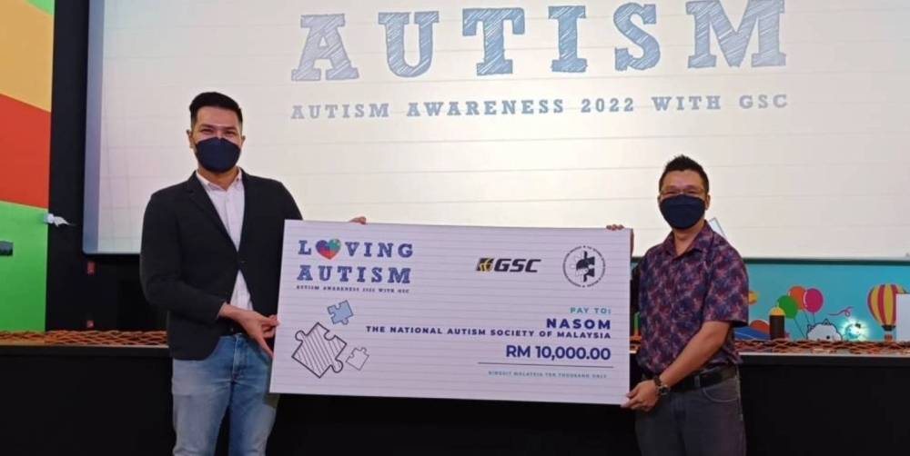 GSC公共关系兼品牌经理沙敏艾萨（Sharmine Ishak）（左）将1万令吉的支票移交给大马自闭症协会主席Julian Wong。-摘自大马自闭症协会脸书-