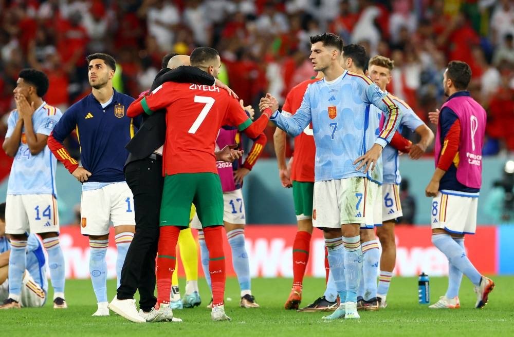 人类的悲欢并不相通！西班牙点球大战输球失意的莫拉塔（右），仍绅士地与摩洛哥球员握手祝贺对方晋8强。-路透社-