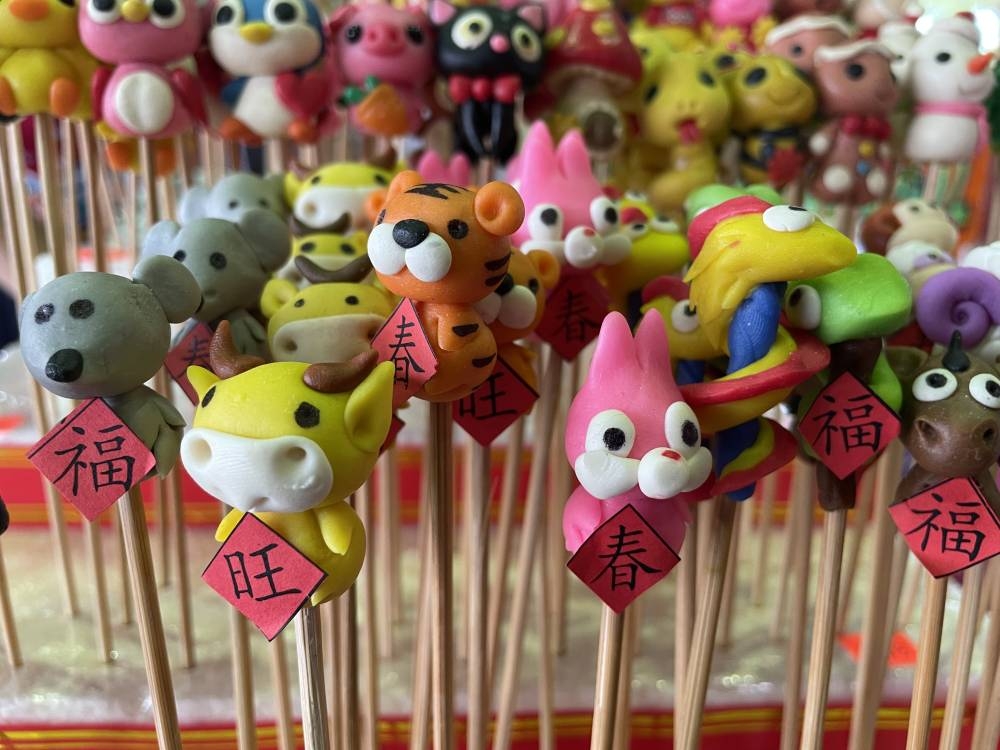 市集摊位也有贩售年画、捏面人、春联、年饼等，增添新年气息。-陈亿佩摄-