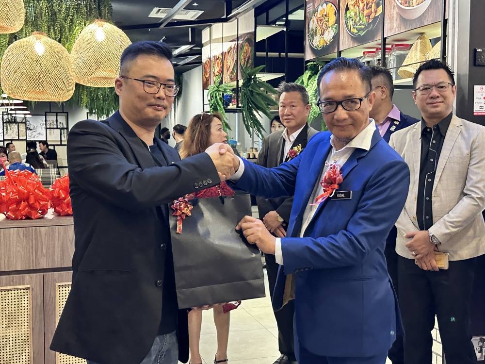 张峰华(左)移交纪念品给阿末礼沙(右)。-方贝欣摄-