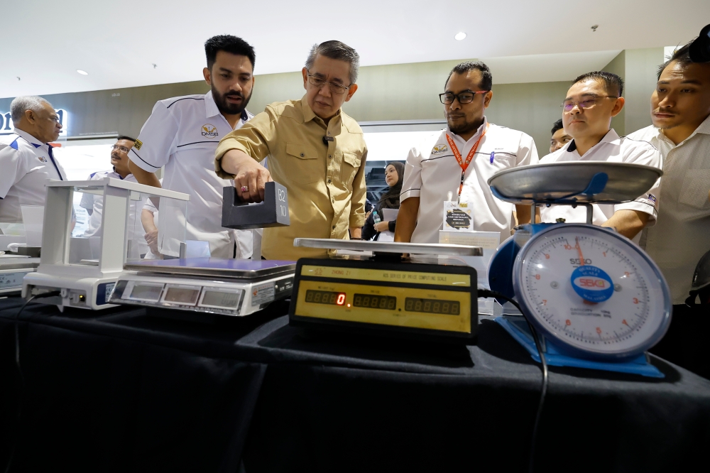 沙拉胡丁（左2）周日主持世界计量日庆典开幕式时，参观展出的各种称重工具。-马新社-