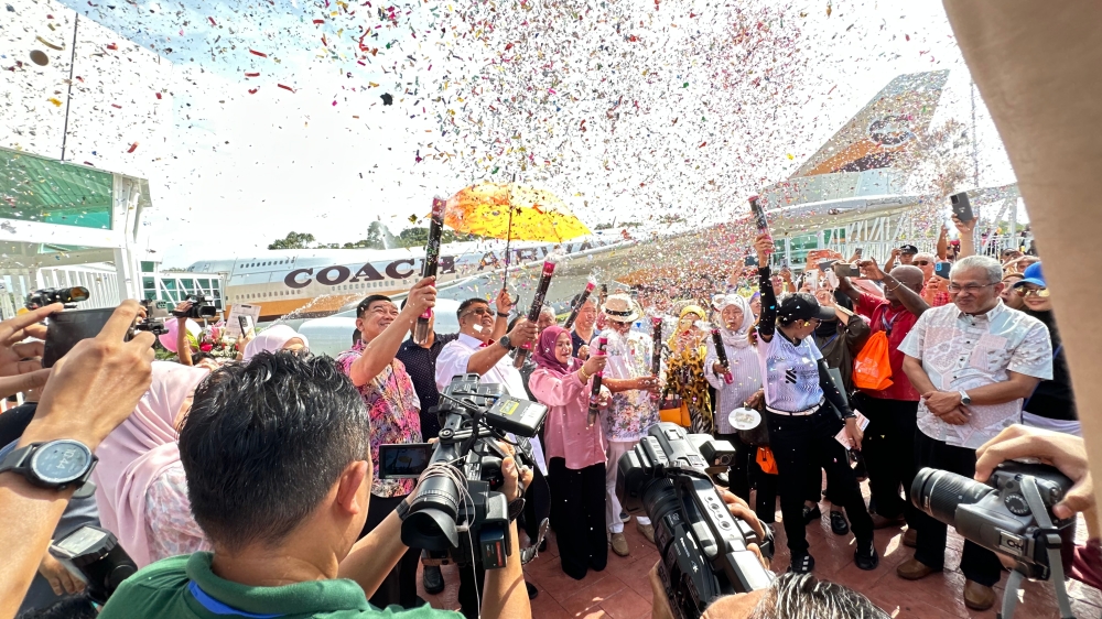 阿都拉勿（中，伞下的白衣者）为Coach Airways主持开幕仪式，并坚信Coach Airways能帮助政府实现2024年马六甲旅游年的目标。-张晓真摄-