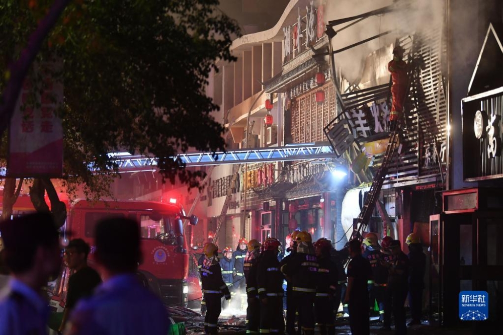 烧烤店一楼的煤气罐首先发生爆炸，再引爆二楼的天然气管道将两层楼之间的楼梯炸毁。图示消防救援人员到达事故现场扑灭明火。-新华社-