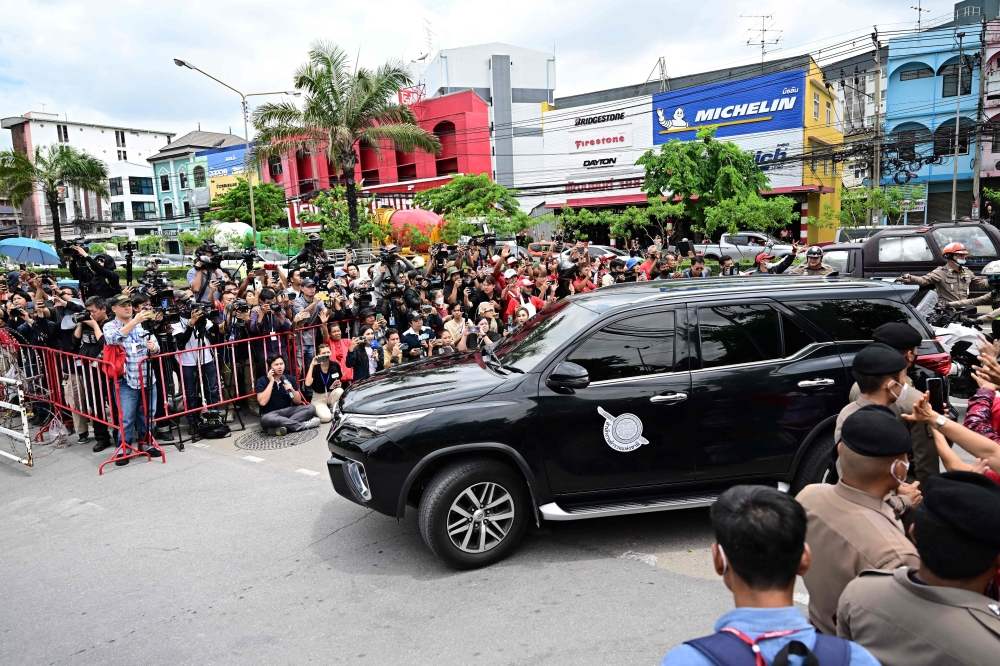 护送塔辛的警方车队从最高法院押送他信前往监狱，准备服刑。曼谷的孔普雷中心监狱外挤满国内外媒体。-法新社-