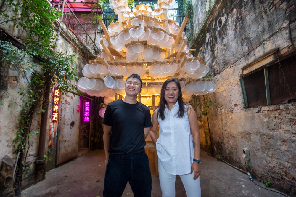 黄凯毅（左起）与郑万馨在《龙月双辉》前合影。-Shafwan Zaidon摄-