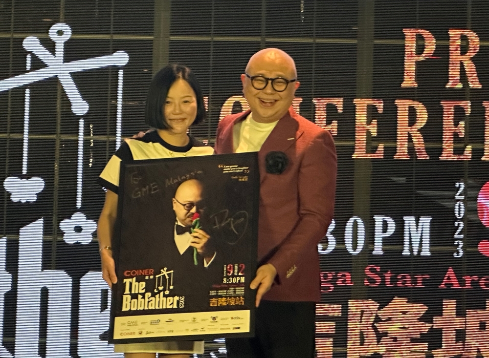 Ah Bob(右)移交签名海报给主办单位代表。-方贝欣摄-