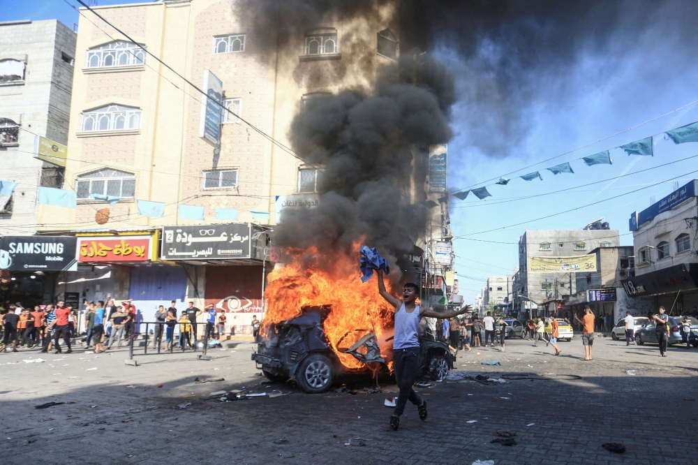巴勒斯坦武装组织哈马斯周五发动火箭攻击加沙走廊一带,街道上汽车起火燃烧。-路透社-