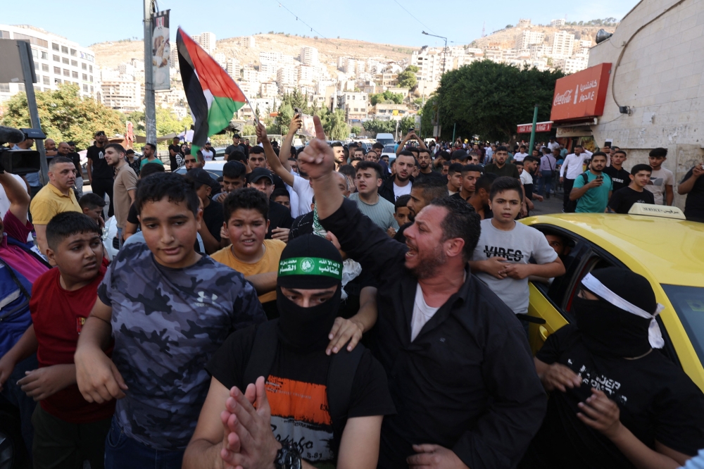 巴勒斯坦人周六在约旦河西岸城市纳布卢斯，庆祝来自加沙地带的武装分子渗入到以色列，这是以巴冲突的一次重大升级。-法新社-