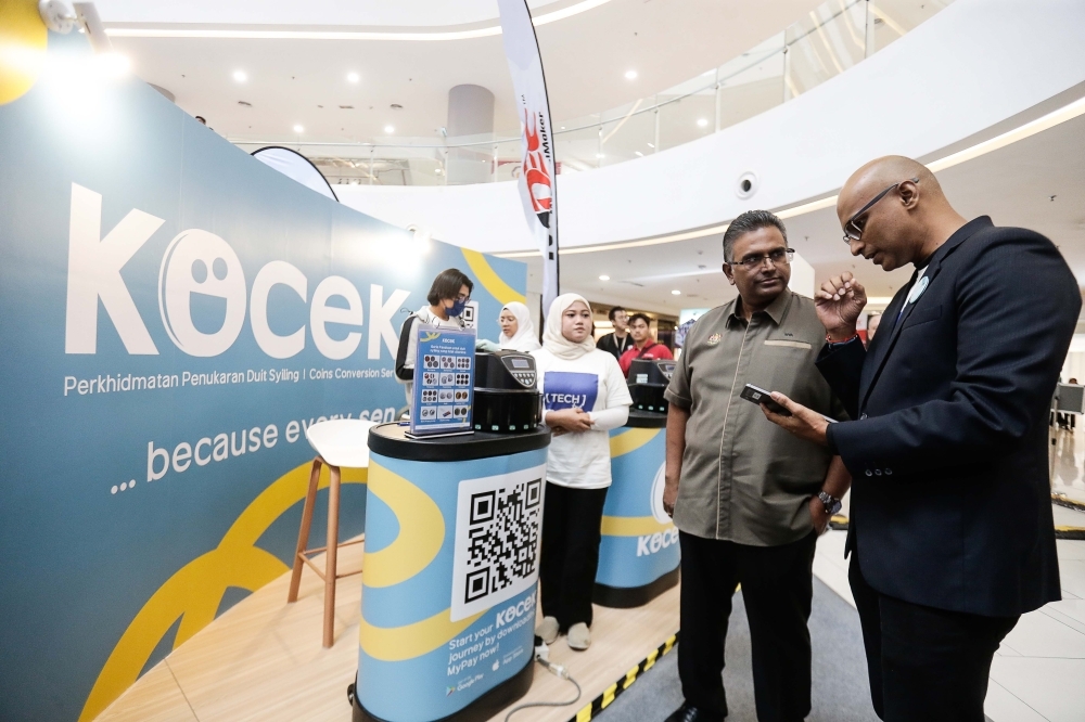 沙希（右起）通讯及数码部副秘书长希瓦介绍Kocek使用方法。.-Sayuti Zainudin摄-