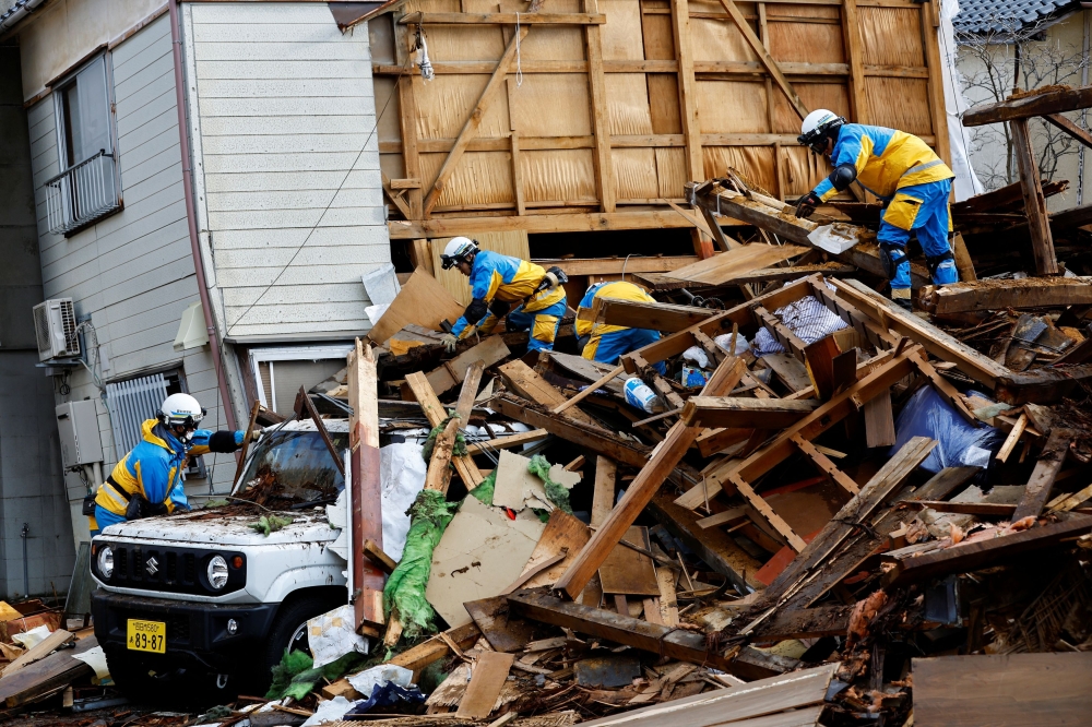 数以千计救援人员继续冒住寒冷天气及大雨，争分夺秒在倒塌的建筑物中搜寻生还者。-路透社-