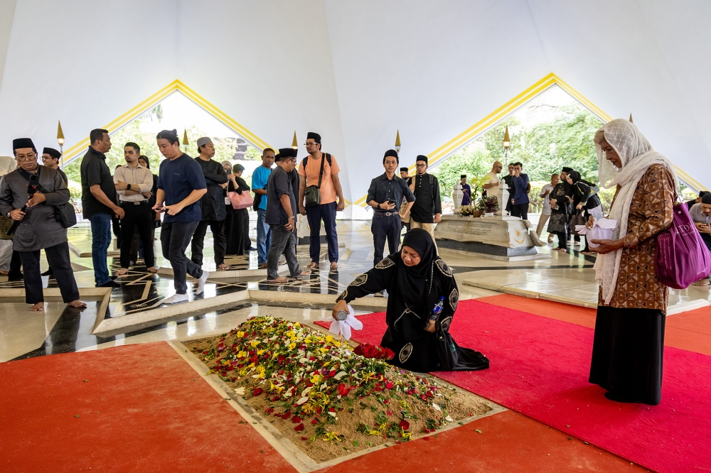 阿都拉下葬英雄陵园，人们献花向阿都拉致敬。-Firdaus Latif摄-