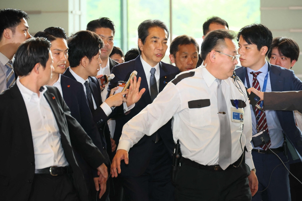 江藤拓（中）周三上午进入首相府时被大批记者包围。 -法新社/日本时事通信社-
