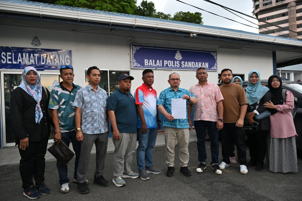 三苏（左6）到警局报案，指控艾伯特污蔑他与安华。-三苏脸书-