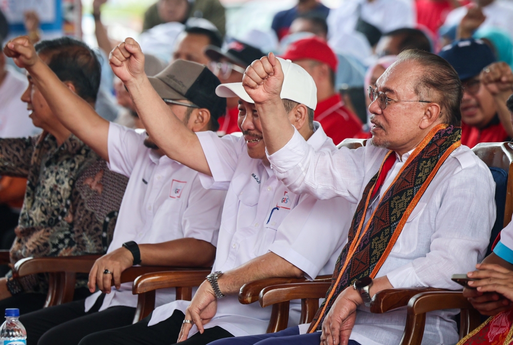 安华（右）赞哈芝芝（中）一直努力为民服务，从不为自己以及家族谋取私利。-马新社-