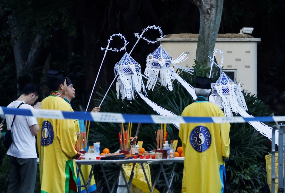 宏福苑大火的罹难者家属周一回到事发地点进行路祭，现场有道士主持仪式。-路透社-