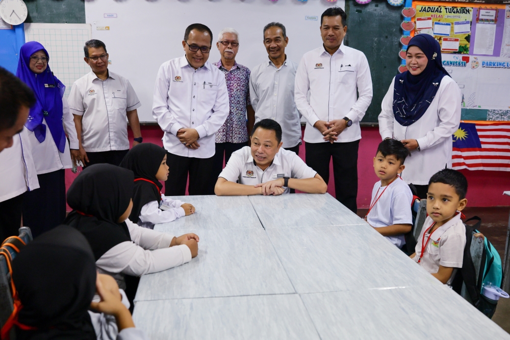 再纳阿巴斯（中）周日在瓜拉登嘉楼的甘榜贡督纳希国小，祝贺一年级新生们开启2026学年的第一天。在登州，507所学校的25万6822名学生于周日开学。-马新社-