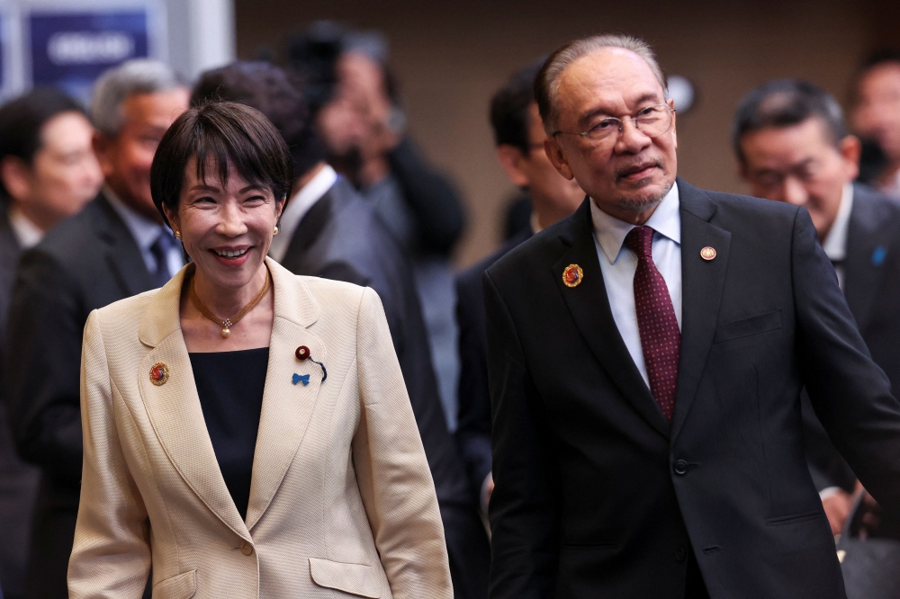 安华（右）恭贺高市早苗领导的自民党在日本众议院选举中取得压倒性胜利。-路透社-