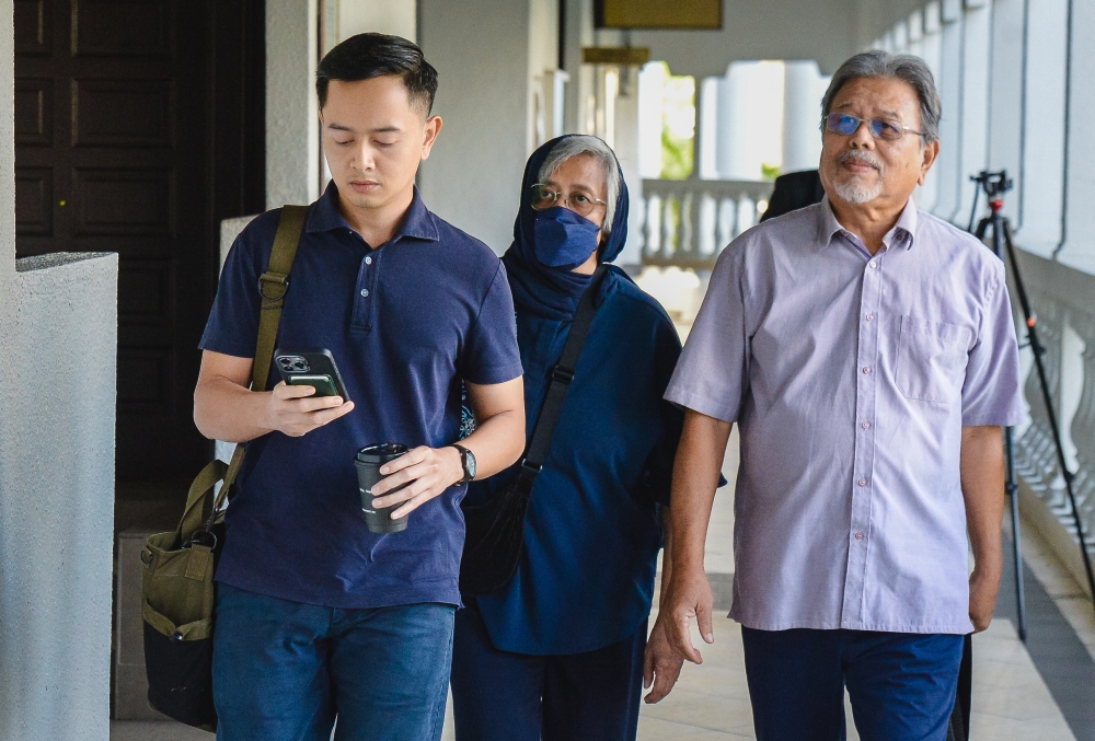 阿丝妮达（中）未按照反贪会指示申报股份，因此被控上庭。-马新社-