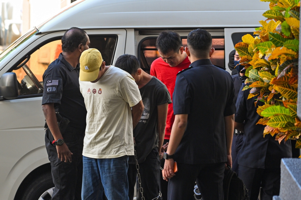 3名被告被押往法庭面控时，低头躲避镁光灯。-马新社-