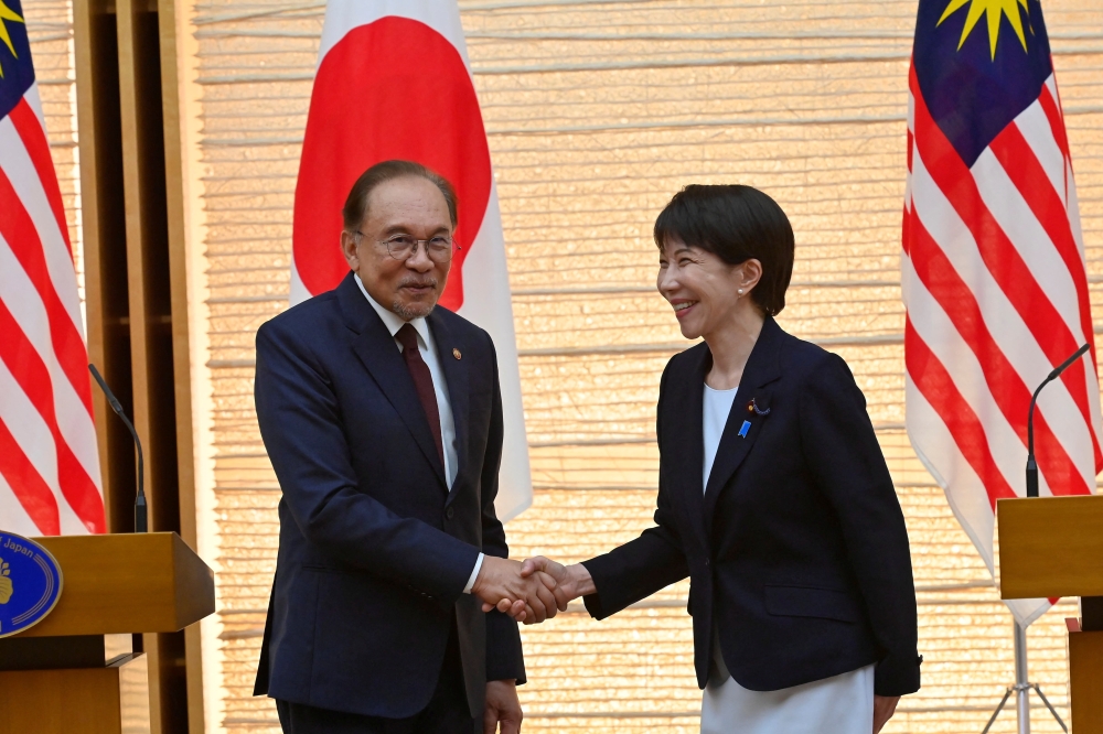 首相安华（左）与日相高市早苗周三在联合记者会结束时握手留影。-路透社-