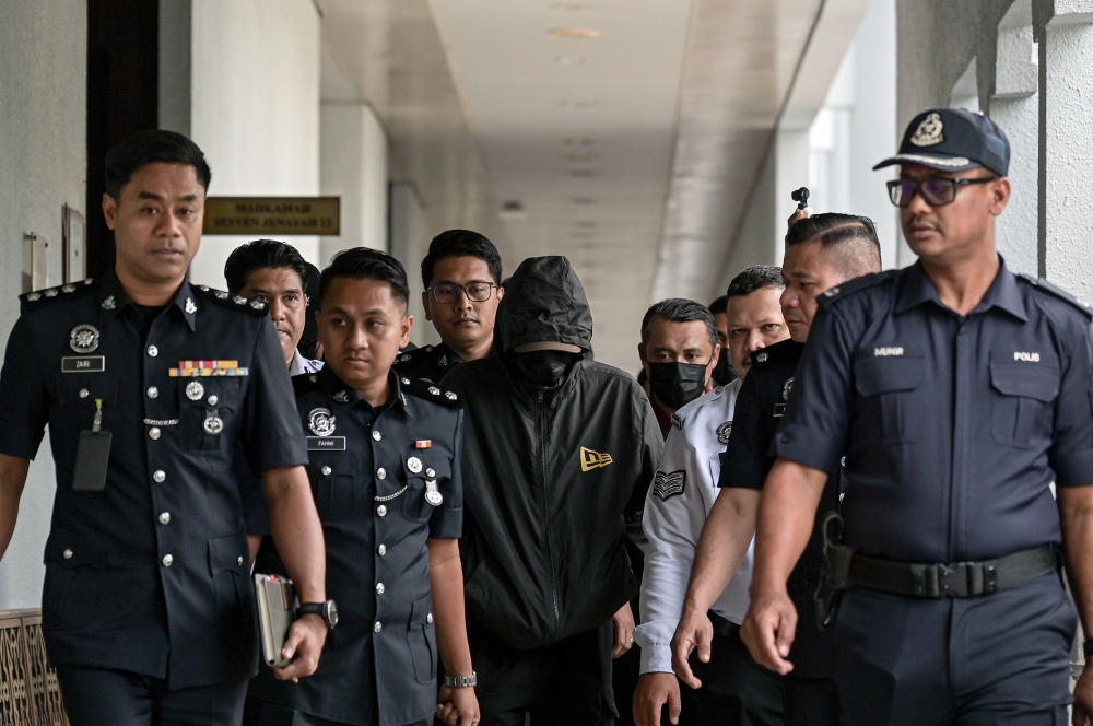 莫哈末阿克巴在罩头面的状态下，被警方押上法庭面控。-马新社-