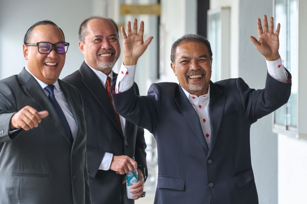 嘉米基尔（右）身穿西装，脸带笑容到法庭面控。-Yusof Isa摄-