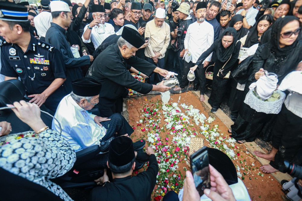 马哈迪、家属以及亲友将鲜花放在墓地上。-Sayuti Zainudin摄-