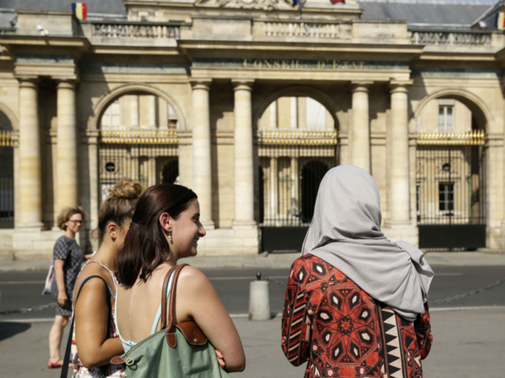 A woman wearing a Muslim headscarf, right, and who refused to be identified, stands outside the Conseil d'Etat, France's top administrative court, in Paris, Friday, Aug. 26, 2016. The court has overturned a town burkini ban amid shock and anger worldwide 