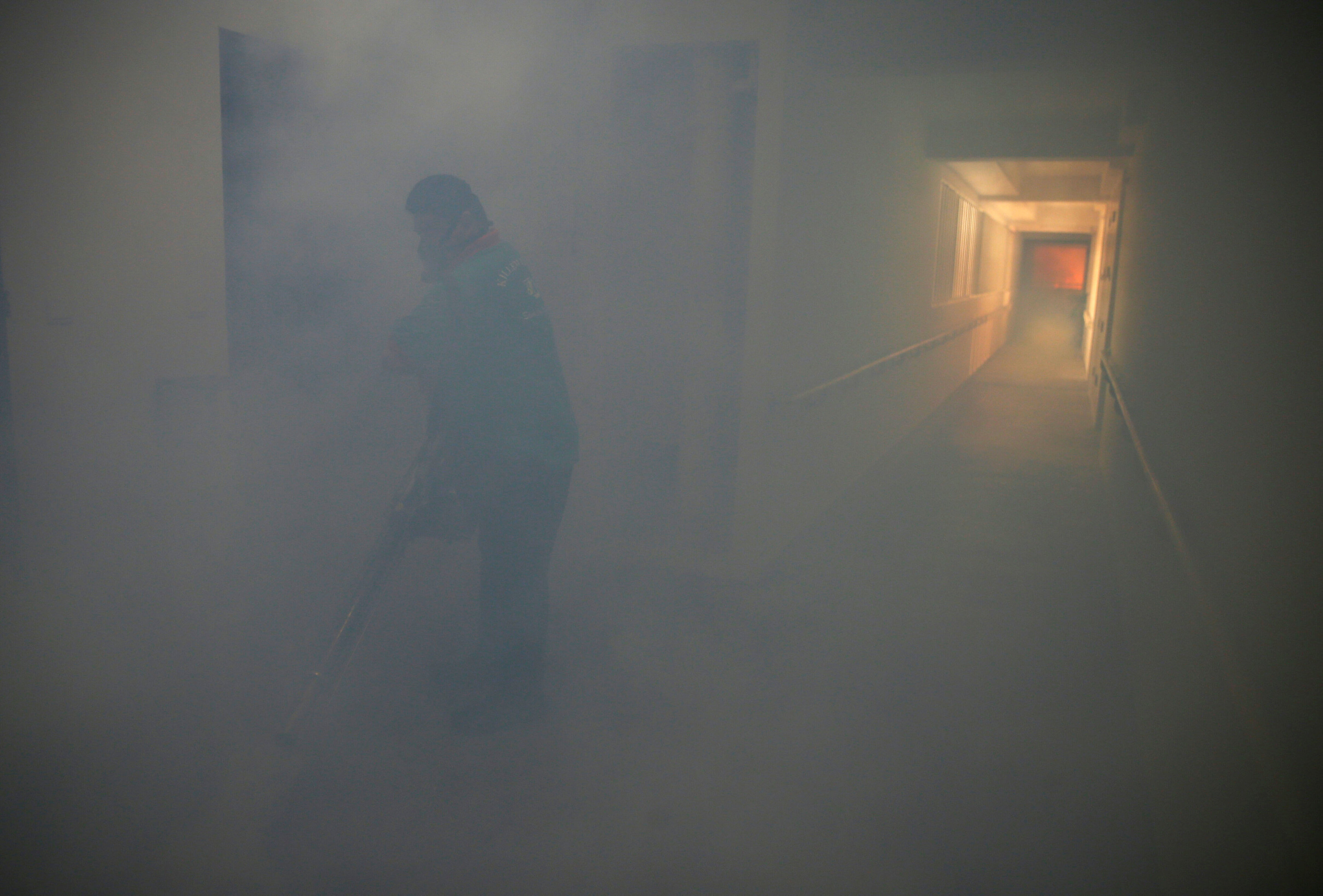 A worker fogs the corridor of a public housing estate in the vicinity where a locally transmitted Zika virus case was discovered, in Singapore August 29, 2016. REUTERS/Edgar Sun