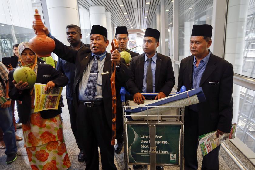 Ibrahim Mat Zin (third left), a local well-known 'bomoh' (the Malay term for a shaman), arrives to perform a ritual to help finding the missing Malaysia Airlines MH370 at Kuala Lumpur International Airport March 12, 2014. u00e2u20acu201d Reuters pic