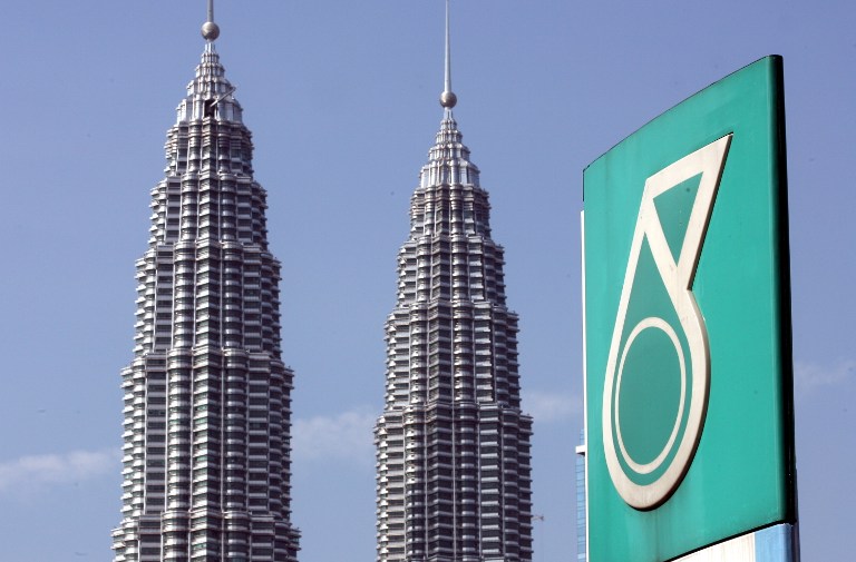 The Petronas twin towers is seen behind the company corporate logo in Kuala Lumpur on May 13, 2011. u00e2u20acu201d AFP pic