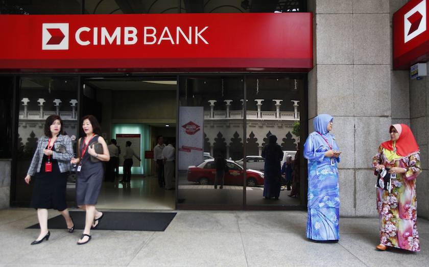 People are seen in front of a CIMB bank office in Kuala Lumpur in this February 25, 2014 file photo. u00e2u20acu201d Reuters pic