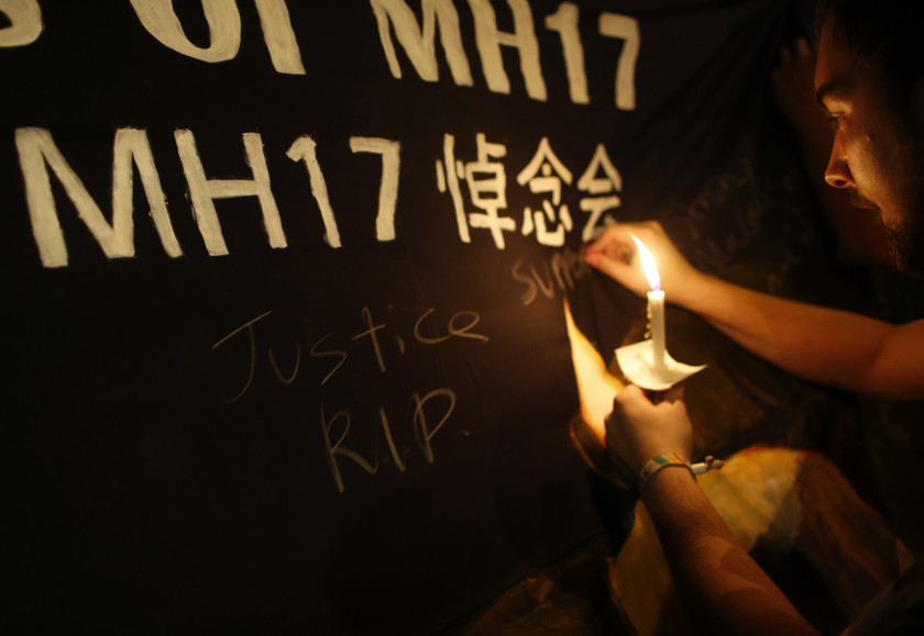 A man writes messages on a banner during a candlelight vigil for victims aboard Malaysia Airlines Flight MH17, which was downed on Thursday over eastern Ukraine, near Chinatown in Kuala Lumpur July 20, 2014. u00e2u20acu201d Reuters pic
