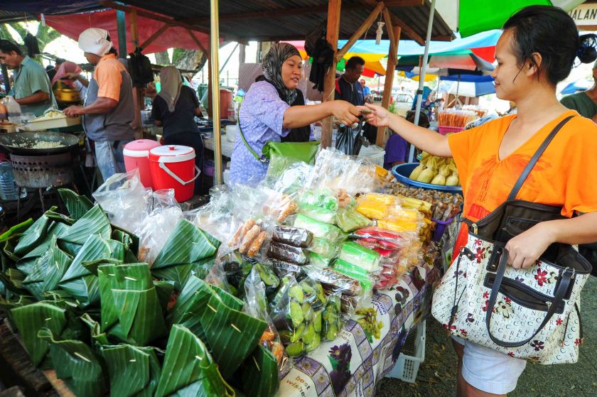 A shopper buys some food from a stall at a Tamu in Sabah. The Tame is a cultural institution in Sabah dating back to the colonial days where people from all over the region gathered to barter and interact. u00e2u20acu201d Picture courtesy of Lano Lan