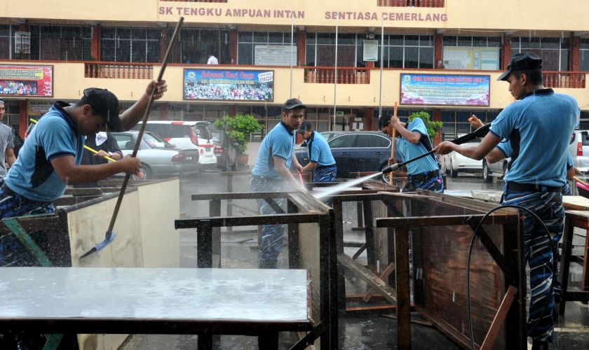 Trainees from the National Service Training Programme at Kem Chenderawasih, Cador Marang help clean up muddied desks at Sekolah Kebangsaan Tengku Ampuan Intan, December 29, 2014. u00e2u20acu201d Bernama pic