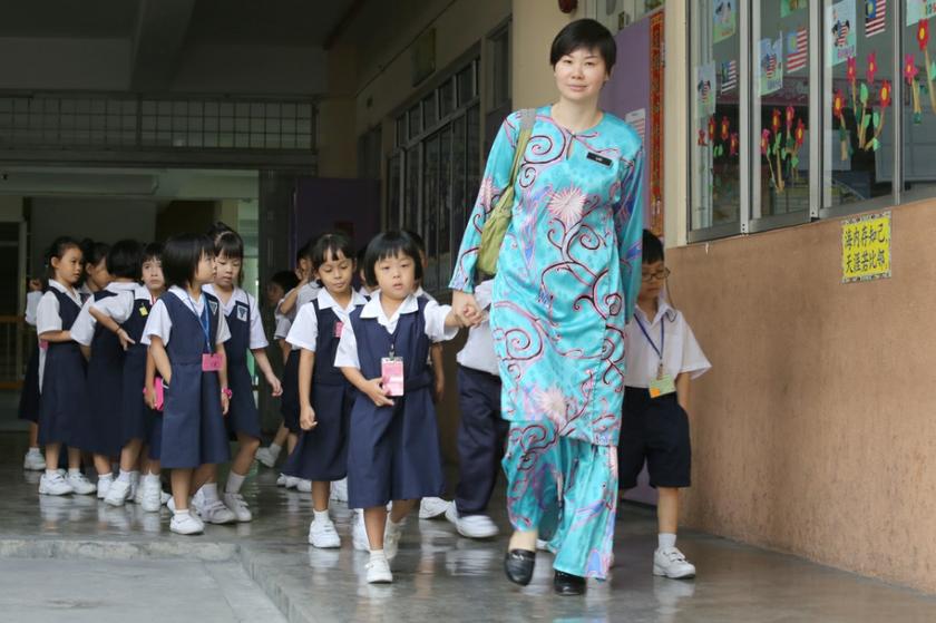 Teacher Lau Chooi Lan leading Sekolah Jenis Kebangsaan Cina Chong Hwa pupils back into their class in Setapak, January 2, 2014. u00e2u20acu201d Picture by Saw Siow Feng