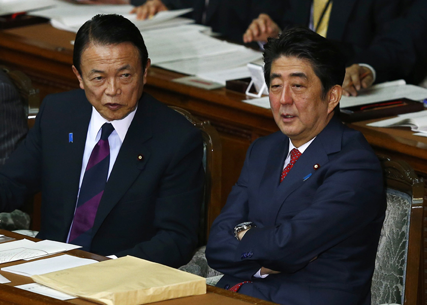 Japan's Prime Minister Shinzo Abe talks to Finance Minister and Deputy Prime Minister Taro Aso at the lower house parliamentary session in Tokyo, February 12, 2015. u00e2u20acu201d Reuters pic