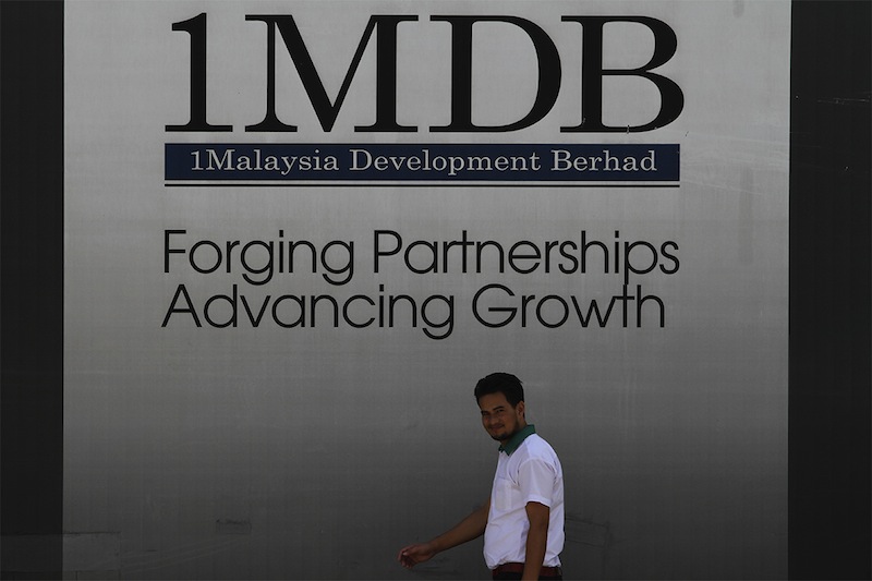 A man walks past a 1 Malaysia Development Berhad (1MDB) billboard in Kuala Lumpur, March 30, 2015. u00e2u20acu201d Picture by Yusof Mat Isa