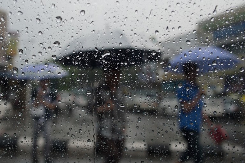 Pedestrians use umbrellas to shelter from heavy rain in Kuala Lumpur March 20, 2015. u00e2u20acu201d AFP pic