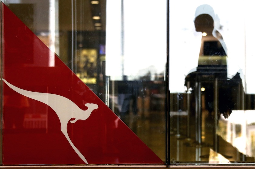 A passenger walks past a Qantas Airways logo at the Sydney International Airport terminal in this July 18, 2014 file photo. u00e2u20acu201d Reuters pic