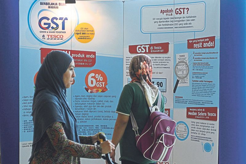 A woman studies an information board on GST in a mall in Petaling Jaya. u00e2u20acu201d Picture by Azneal Ishak. u00e2u20acu201d Pic by Malay Mail