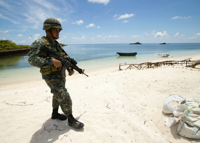 Philippine soldier Tychico Octobre patrols a beach in Pagasa Island (Thitu Island) at the Spratly group of islands in the South China Sea, west of Palawan, on May 11, 2015. u00e2u20acu201d AFP pic