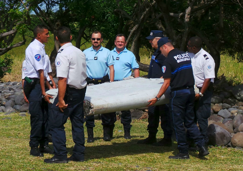 French gendarmes and police carry a large piece of plane debris which was found on the beach in Saint-Andre, on the French Indian Ocean island of La Reunion, July 29, 2015. u00e2u20acu201d Reuters pic