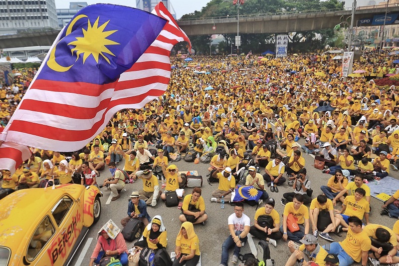 Bersih 4 rally participants brave the rain as they listen to speeches in downtown Kuala Lumpur, August 30, 2015. u00e2u20acu201d Picture by Saw Siow Feng