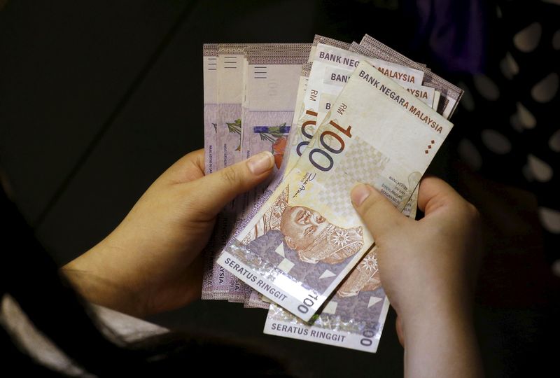 A customer counts her ringgit notes outside a money changer at the central business district in Singapore August 25, 2015. u00e2u20acu201d Reuters pic