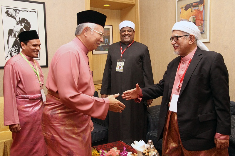Prime Minister Datuk Seri Najib Razak (left) and PAS president Datuk Seri Abdul Hadi Awang greet each other during the Al-Azhar Alumni Regional Meet 2015 at Grand Seasons Hotel in Kuala Lumpur, December 17, 2015. u00e2u20acu2022 Picture by Yusof Mat Is
